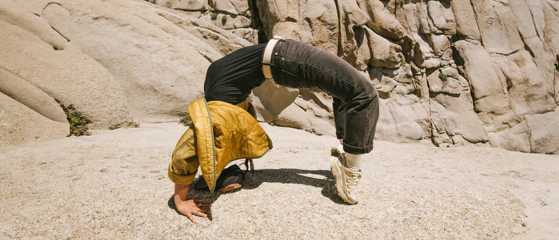 woman doing acrobatic trick wearing belt and yellow jacket