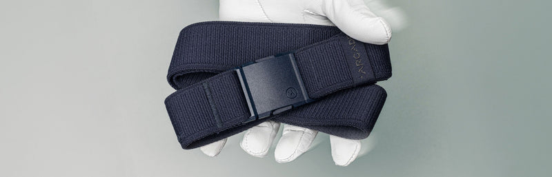 man wearing a white glove holding a blue belt