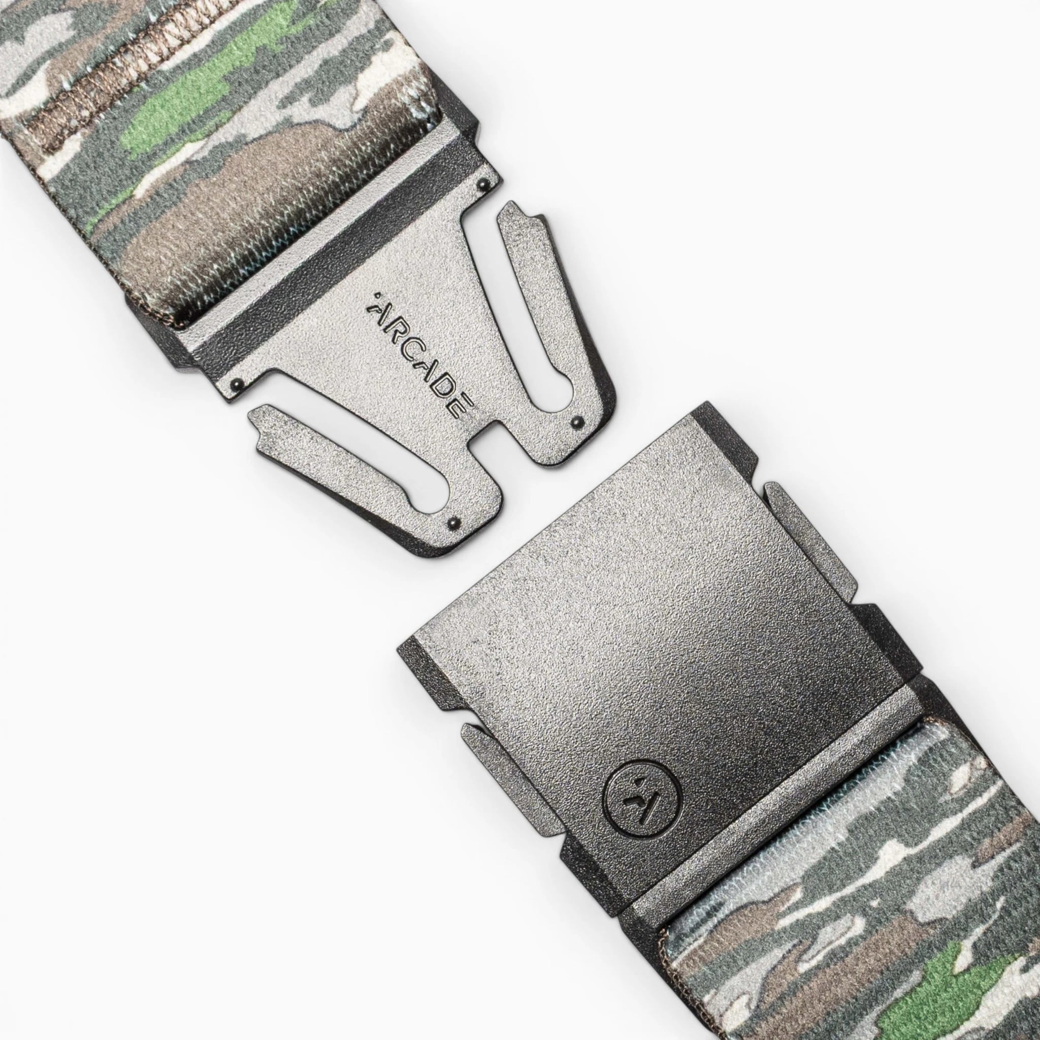 Close-up of the Realtree Camo Original by Arcade Belts, a stretch webbing belt with a camouflage pattern, partially open metal buckle engraved “ARCADE,” and a small lower logo.