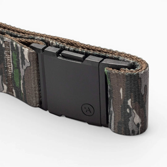 A close-up of the Arcade Belts Realtree Camo Original, featuring stretch webbing and a matte black rectangular buckle, displayed on a white background.