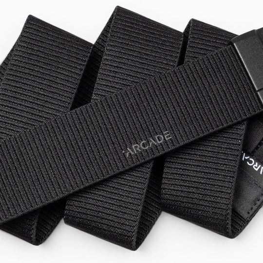 A close-up of the Aero Mag by Arcade Belts—a black, woven fabric belt with "Arcade" subtly printed on it—showcasing its textured material and an adjustable, durable buckle featuring a tension lock for secure fastening.