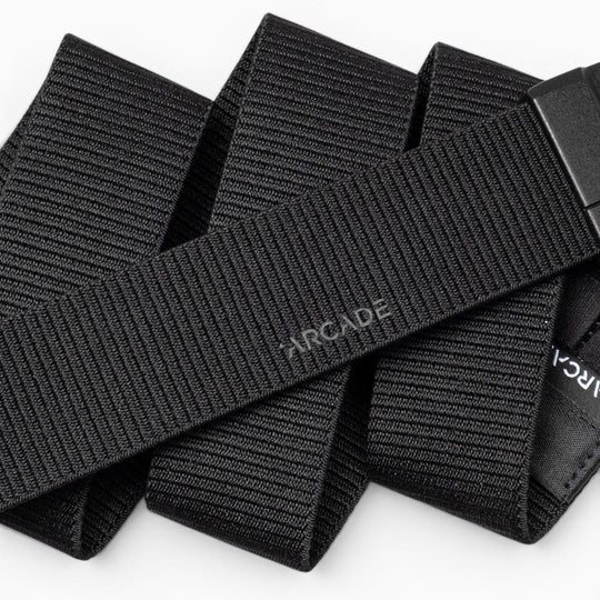 A close-up of the Aero Mag by Arcade Belts—a black, woven fabric belt with "Arcade" subtly printed on it—showcasing its textured material and an adjustable, durable buckle featuring a tension lock for secure fastening.