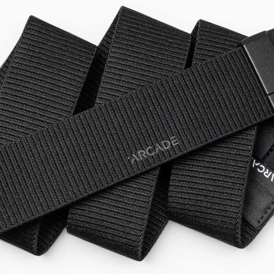 A close-up of the Aero Mag by Arcade Belts—a black, woven fabric belt with "Arcade" subtly printed on it—showcasing its textured material and an adjustable, durable buckle featuring a tension lock for secure fastening.