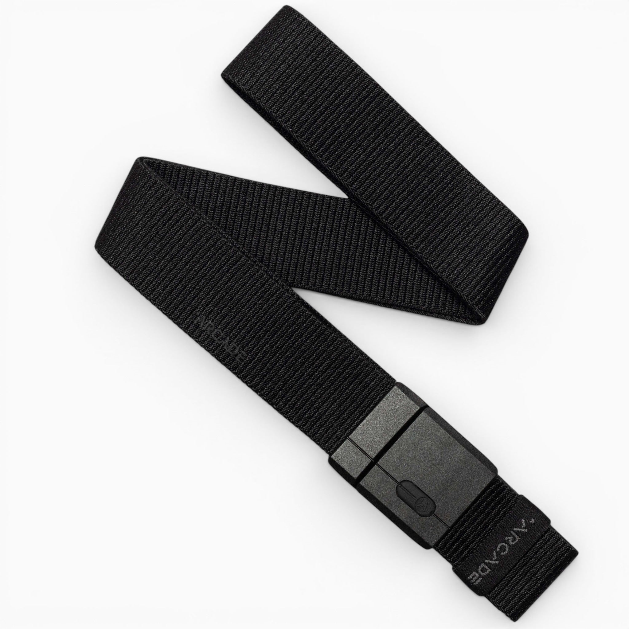 A black Mag Kit II woven nylon stretch belt by Arcade Belts, featuring a rectangular black plastic buckle, is displayed on a white background. The belt is partially folded, showcasing its flexible texture and modern minimalist design that exemplifies the adventurous spirit of Arcade Belts.