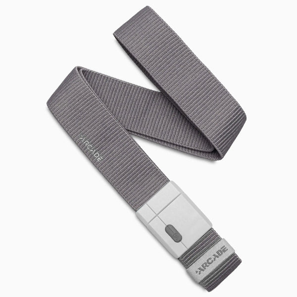 An Aero Mag belt from Arcade Belts, made of gray woven fabric and featuring a rectangular gray plastic buckle, is coiled on a white background. The brand name Arcade Belts is visible on both the belt and the durable buckle, designed for long-lasting wear.
