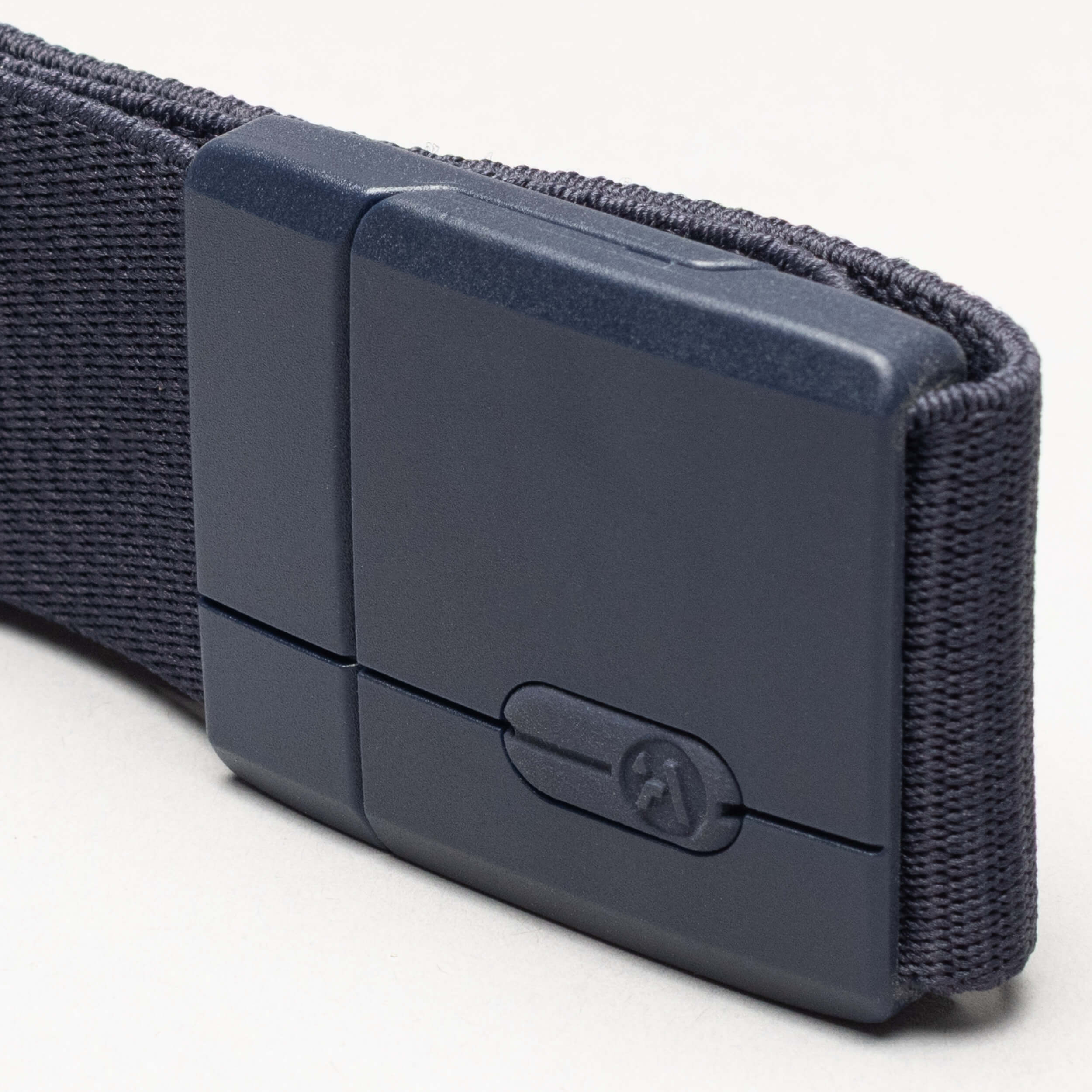 A close-up of the Aero belt by Arcade Belts, featuring dark gray fabric and a matte rectangular plastic buckle, displayed against a light background.