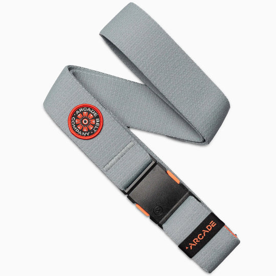 The Arcade Belt Co. by Arcade Belts in Cloud features a black plastic buckle, orange stitching, a circular black and orange limited patch, and an ARCADE logo tag for subtle pops of color.