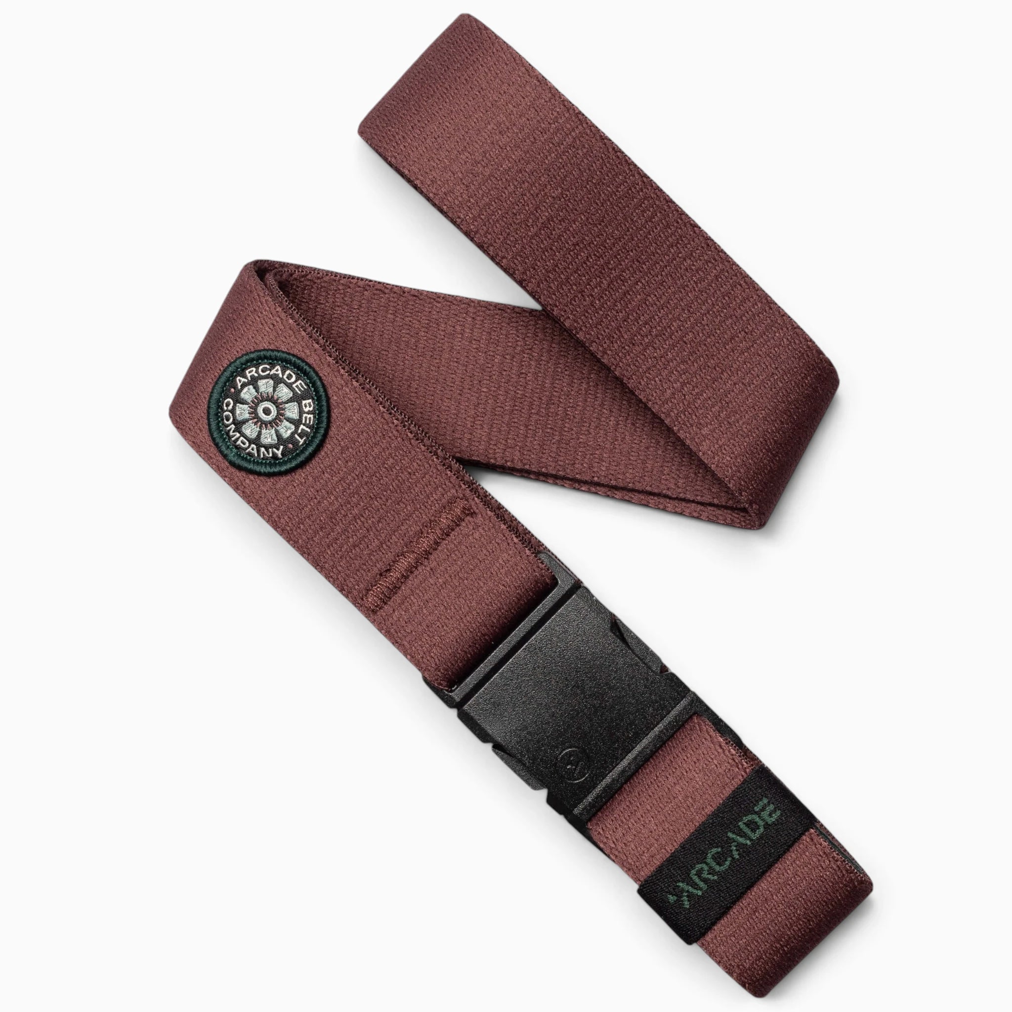 A burgundy performance stretch belt from Arcade Belts, featuring a black plastic buckle, a limited patch design with a round black and white Arcade Belt Co. logo patch, and a small black Arcade tag near the buckle.