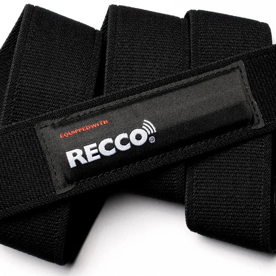 Close-up of the Arcade Belts Recco black performance stretch belt with a white and red "Equipped with RECCO" label, highlighting its textured fabric, detailed stitching, and integrated backup RECCO safety technology.
