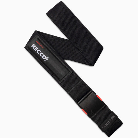 The Arcade Belts Recco in black is a performance stretch belt with a plastic buckle, RECCO technology for enhanced safety, a reflector patch, ARCADE embossed near the end, and a red accent on the buckle.
