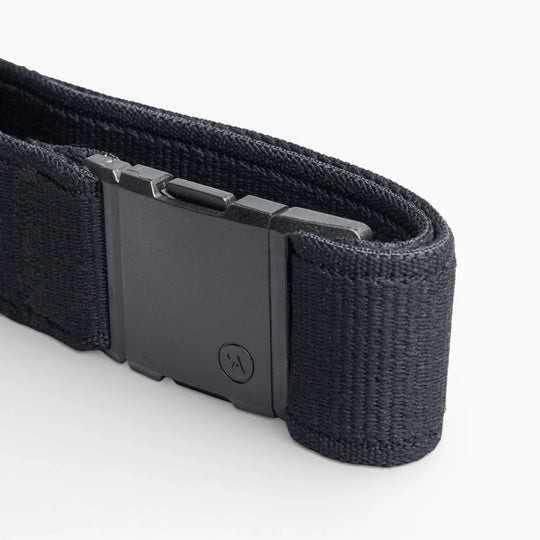 A close-up of the Arcade Belts Atlas, a black elastic stretch belt with a rectangular plastic buckle featuring a subtle logo, displayed on a white background. The webbing texture is clearly visible.