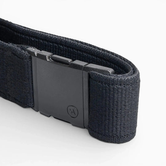A close-up of the Arcade Belts Atlas, a black elastic stretch belt with a rectangular plastic buckle featuring a subtle logo, displayed on a white background. The webbing texture is clearly visible.