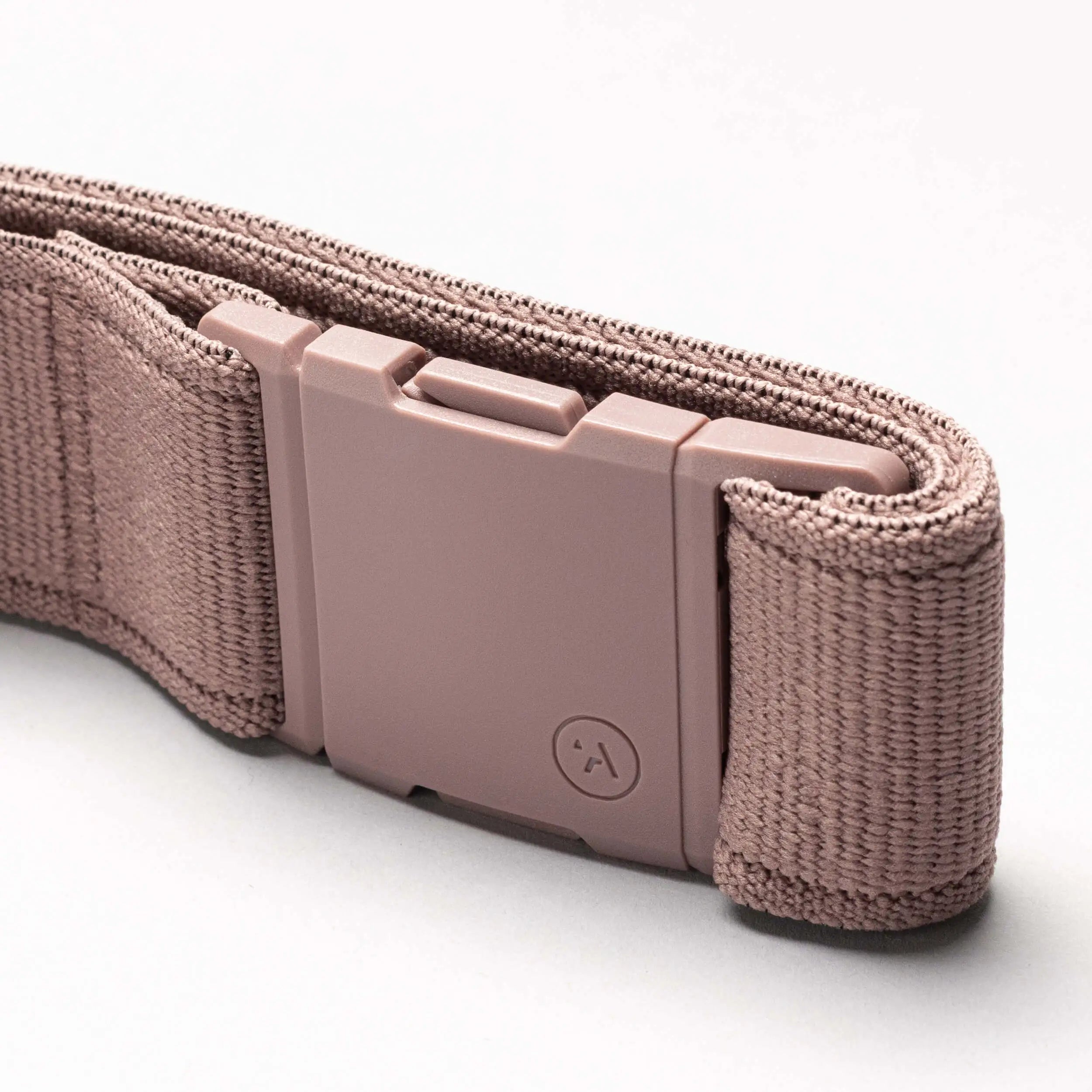A close-up view of the Atlas Elastic Stretch Belt by Arcade Belts in mauve, featuring a matching rectangular plastic buckle against a light background.