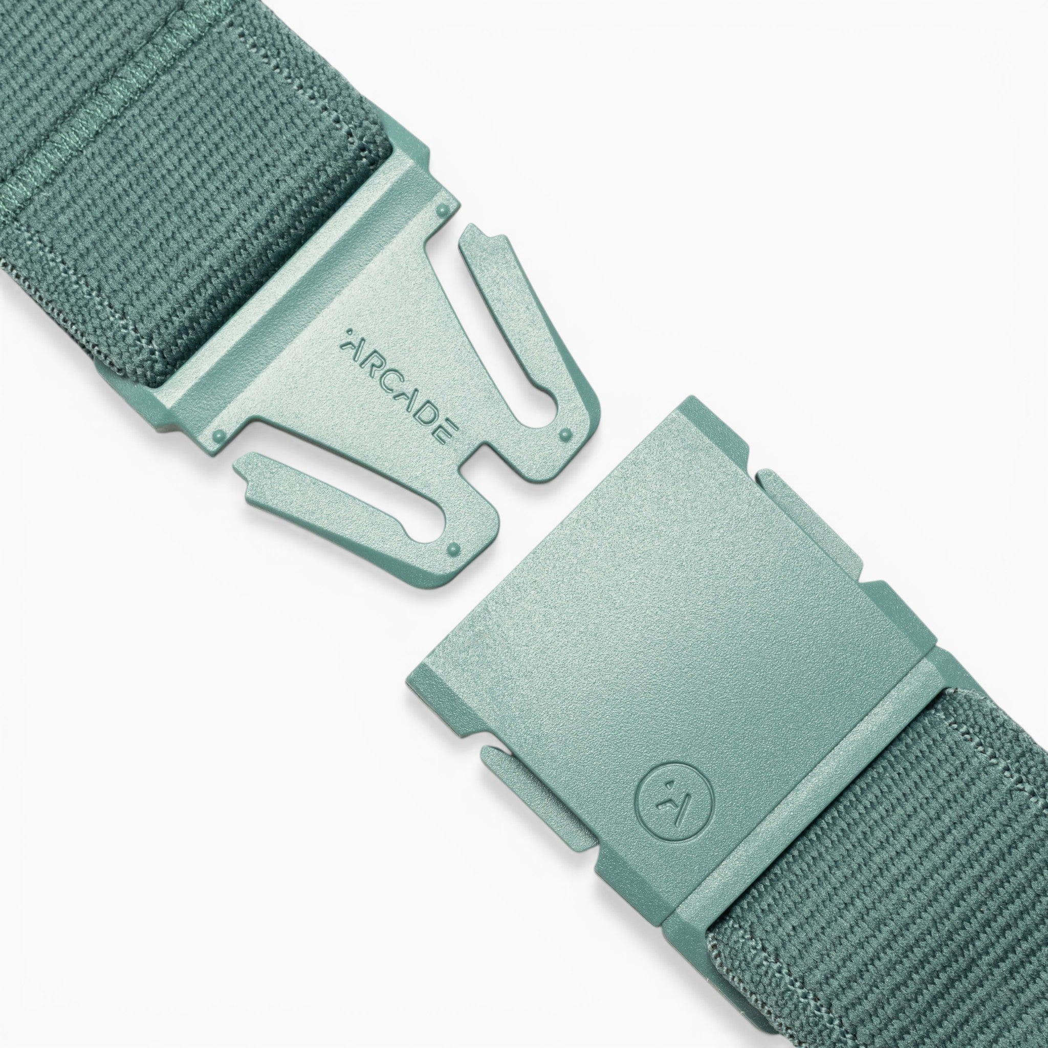 Close-up of a green woven fabric belt featuring an A2 plastic quick-release buckle with its separate components displaying the Arcade Belts brand name and logo. The Atlas edition emphasizes the comfort and versatility characteristic of Arcade Belts’ performance stretch belts.