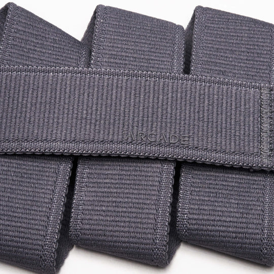Close-up of the Atlas belt by Arcade Belts, crafted in grey stretch webbing. The word ARCADE is stitched at the center, showcasing its signature woven texture and neatly folded design.