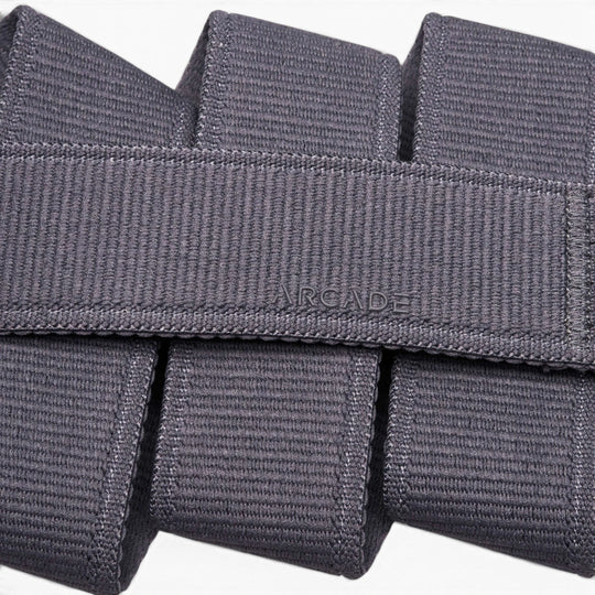 Close-up of the Atlas belt by Arcade Belts, crafted in grey stretch webbing. The word ARCADE is stitched at the center, showcasing its signature woven texture and neatly folded design.