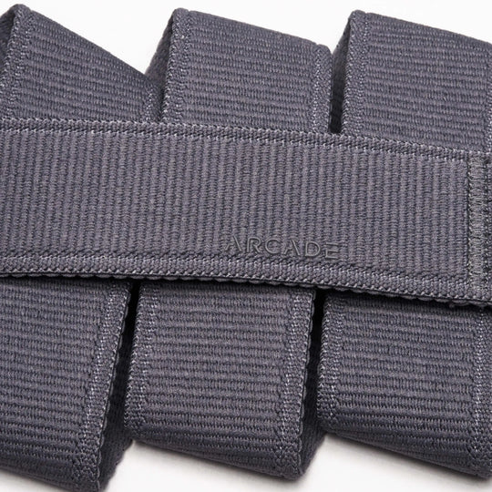 Close-up of the Atlas belt by Arcade Belts, crafted in grey stretch webbing. The word ARCADE is stitched at the center, showcasing its signature woven texture and neatly folded design.