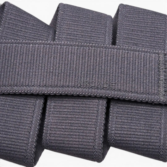 Close-up of the Atlas belt by Arcade Belts, crafted in grey stretch webbing. The word ARCADE is stitched at the center, showcasing its signature woven texture and neatly folded design.