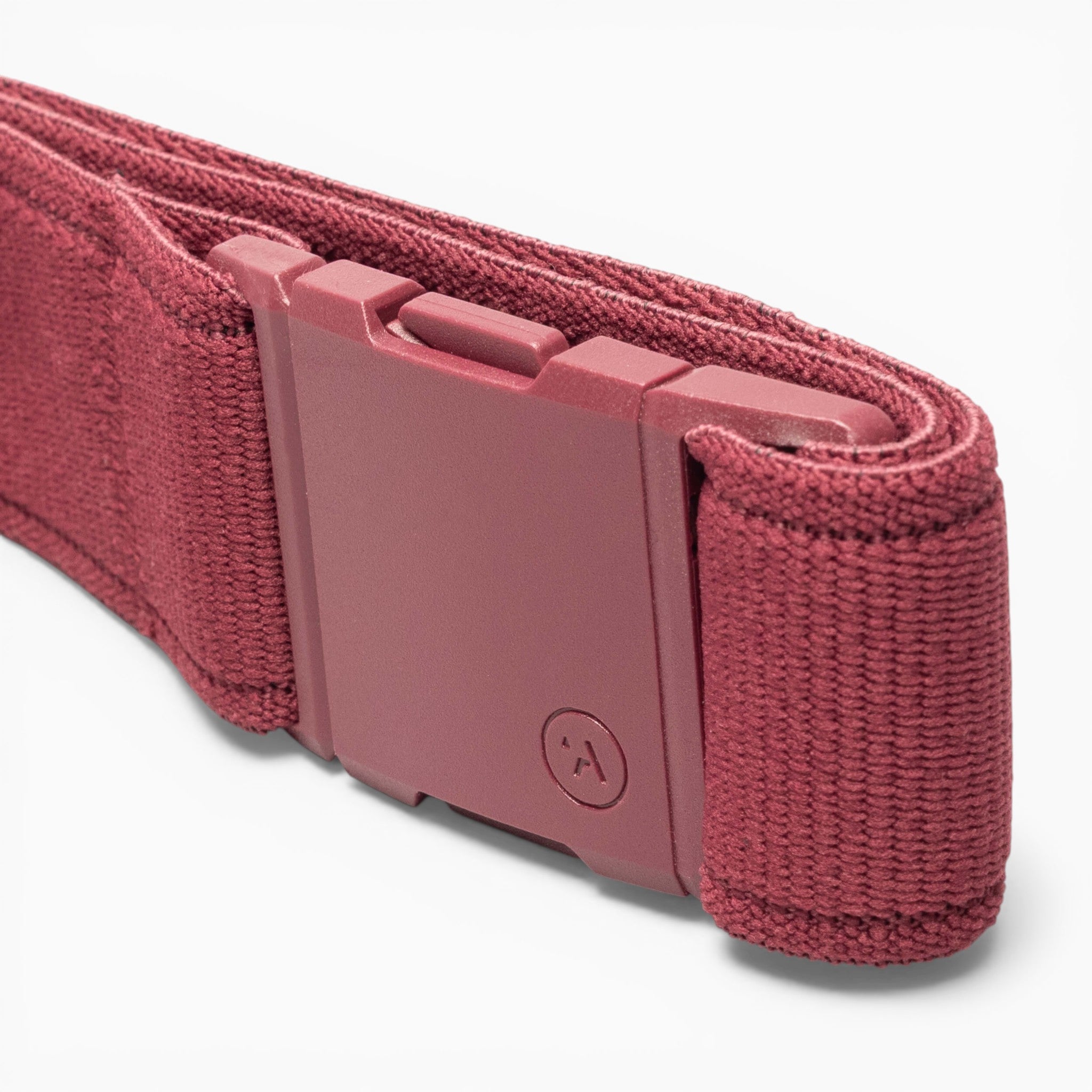 A close-up of the Atlas adventure belt by Arcade Belts in maroon fabric, featuring a matching A2 buckle, neatly rolled and set against a white background.