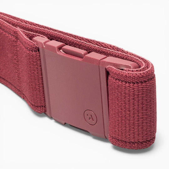 A close-up of the Atlas adventure belt by Arcade Belts in maroon fabric, featuring a matching A2 buckle, neatly rolled and set against a white background.