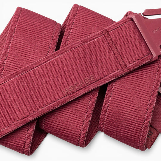 A close-up of the Atlas adventure belt by Arcade Belts, featuring red woven fabric and a matching red A2 buckle, highlighting the textured material and the word “ARCADE” embossed on the belt.