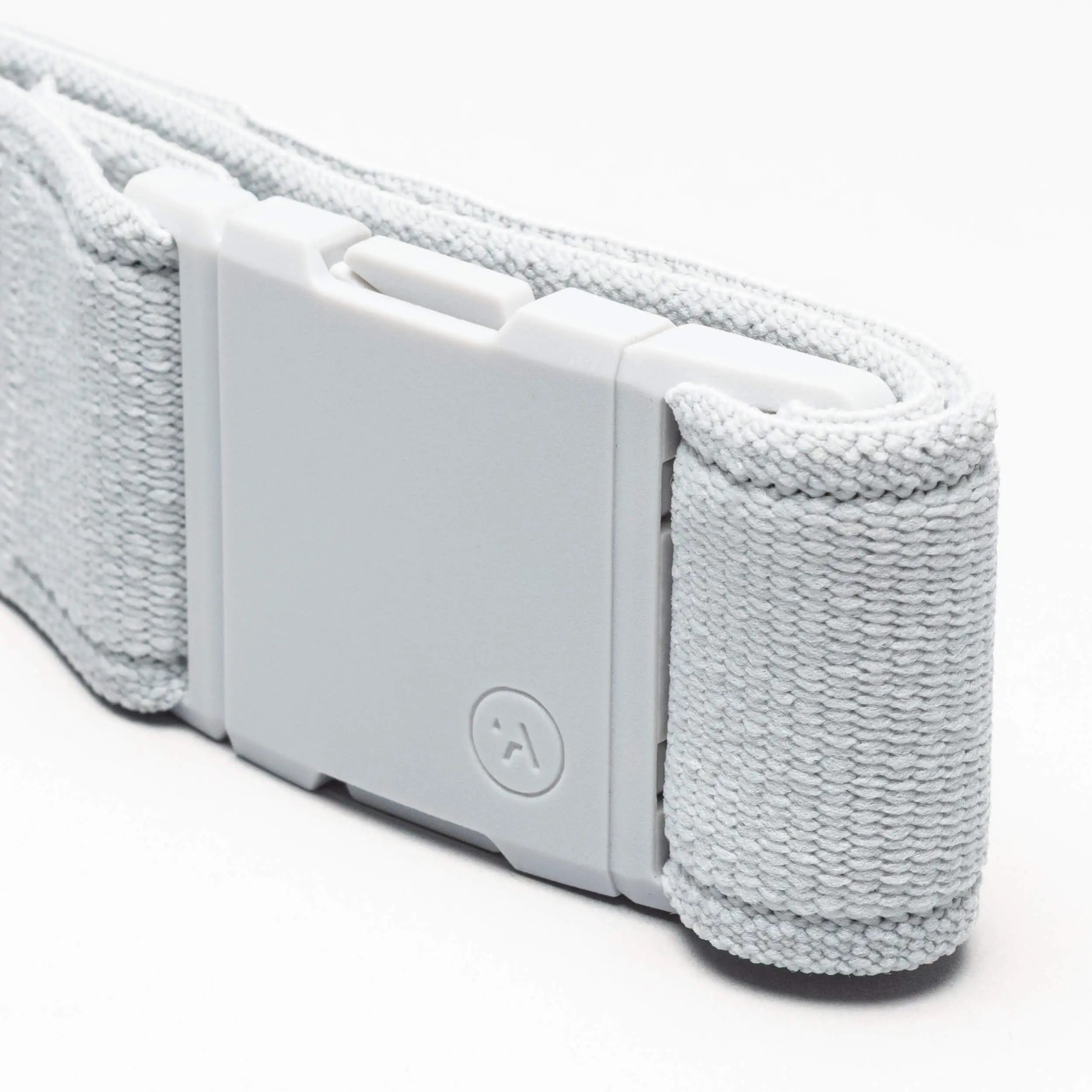 A close-up of the Atlas adventure belt by Arcade Belts shows its light gray fabric strap with a rectangular plastic A2 buckle and small circular logo. The belt's texture is visible against a white background.