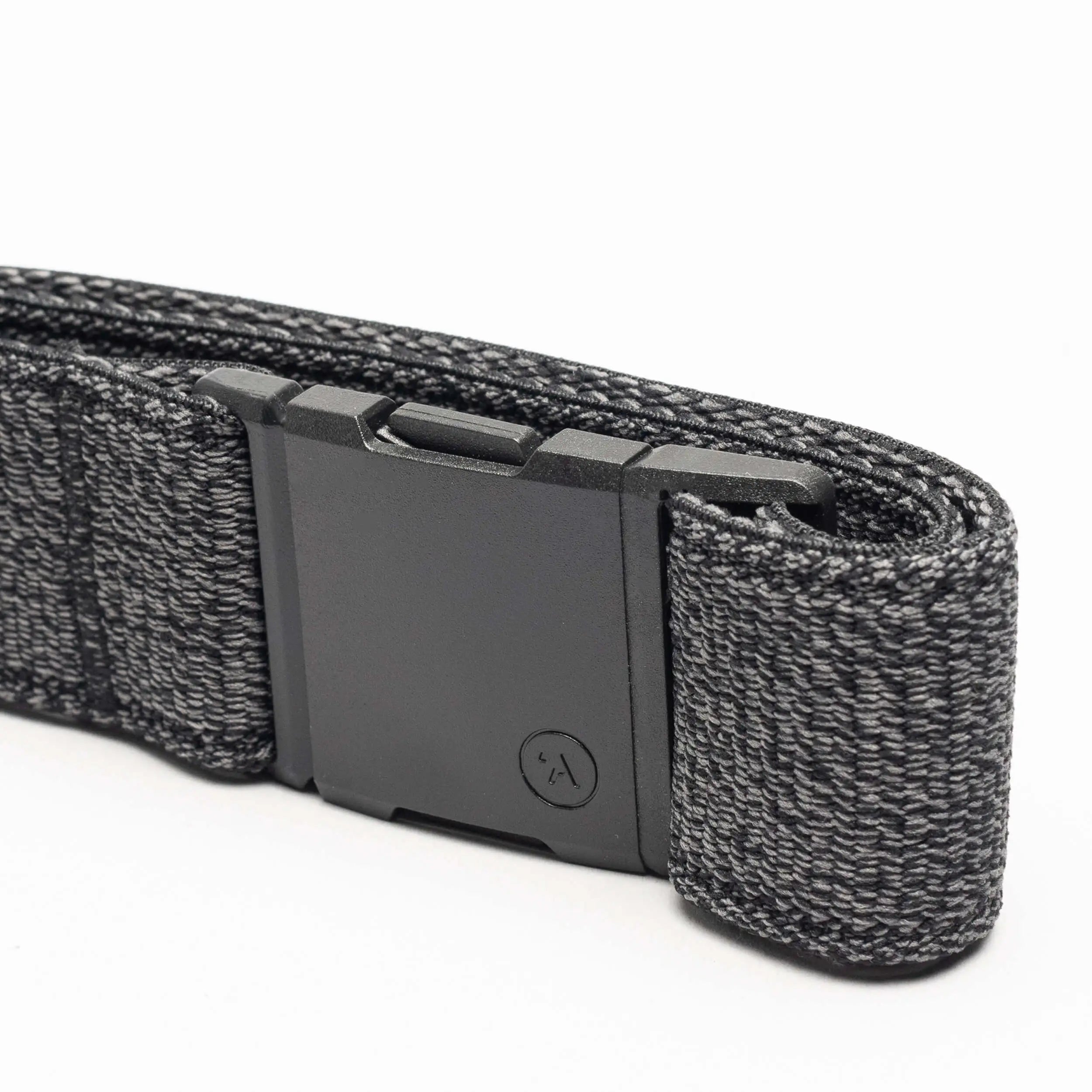 A close-up of the Atlas belt by Arcade Belts, showing its black elastic stretch design with a matte black rectangular buckle and a textured woven pattern with lighter gray threads, neatly folded on a white background.