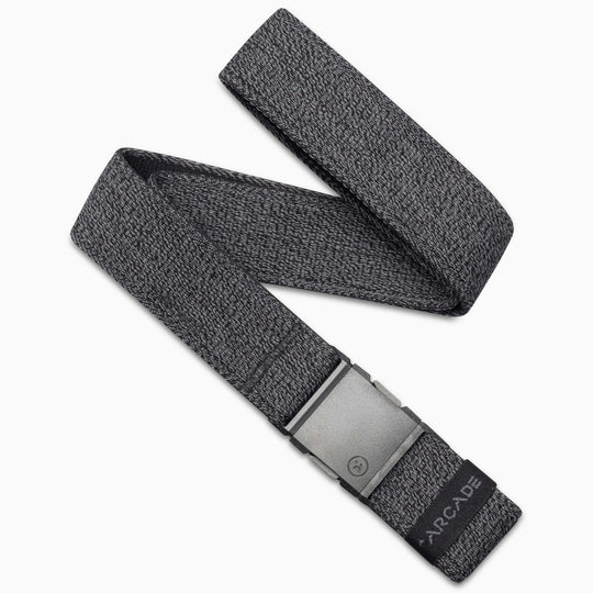 The Atlas Kit by Arcade Belts is a grey woven elastic stretch belt with a matte grey rectangular buckle, shown in a zigzag layout. A black tab at the end features ARCADE branding in white.
