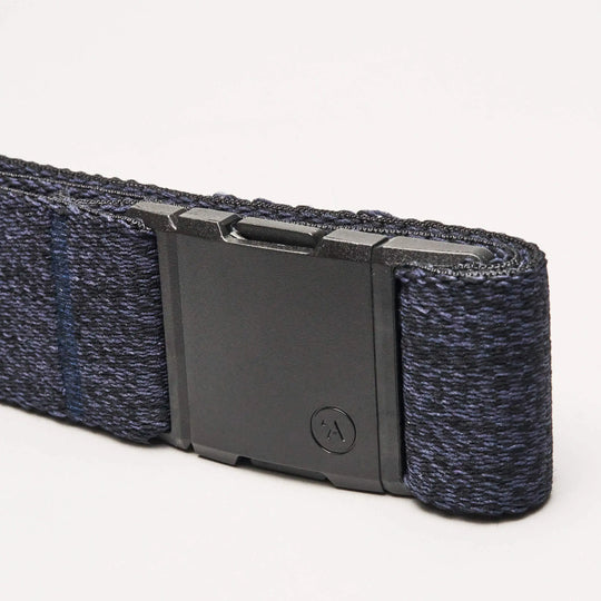 A close-up of the Atlas Low Profile Belt by Arcade Belts in navy blue, showcasing stretch webbing and a matte black rectangular buckle, set against a plain light background.