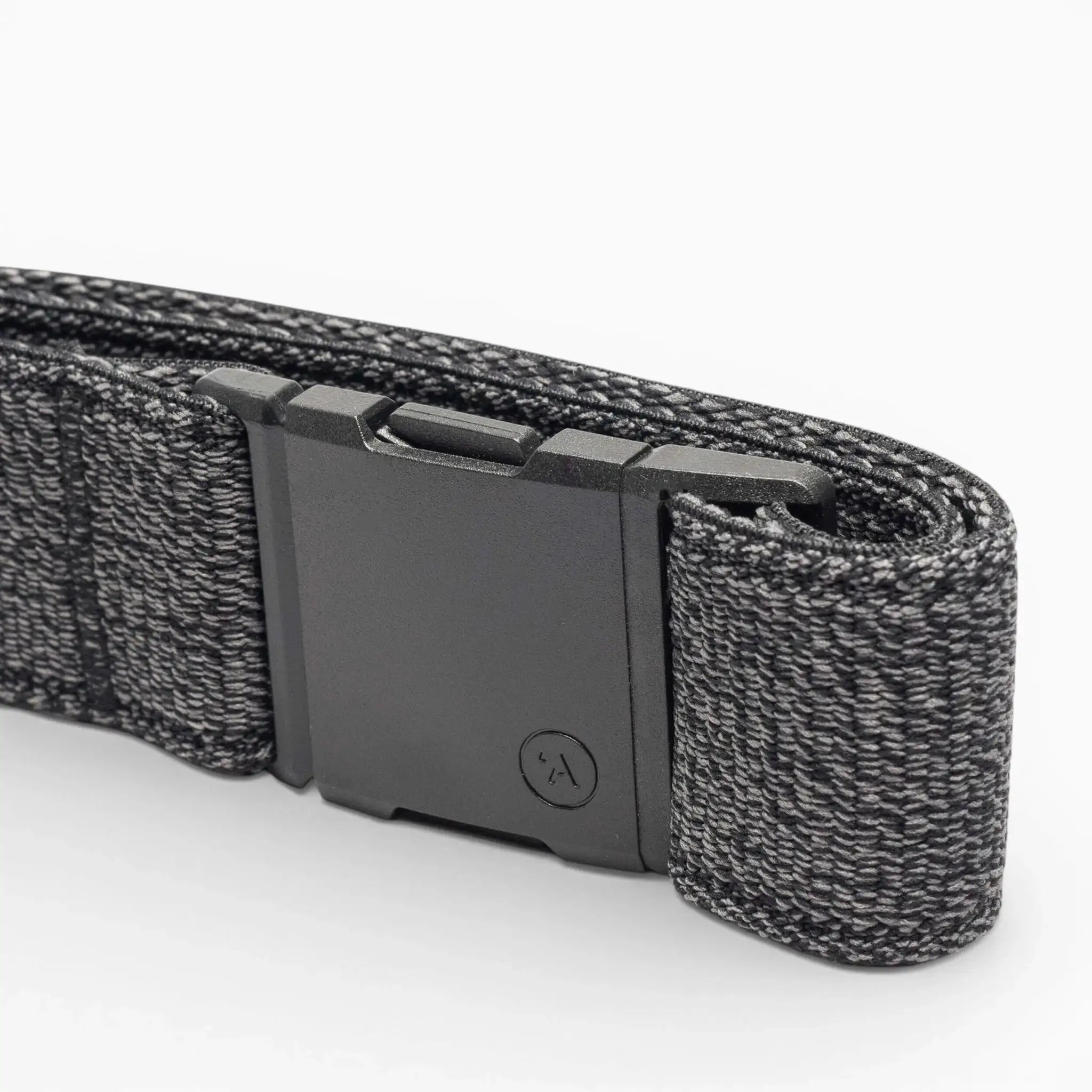 A close-up of the Atlas belt by Arcade Belts, showing its black elastic stretch design with a matte black rectangular buckle and a textured woven pattern with lighter gray threads, neatly folded on a white background.
