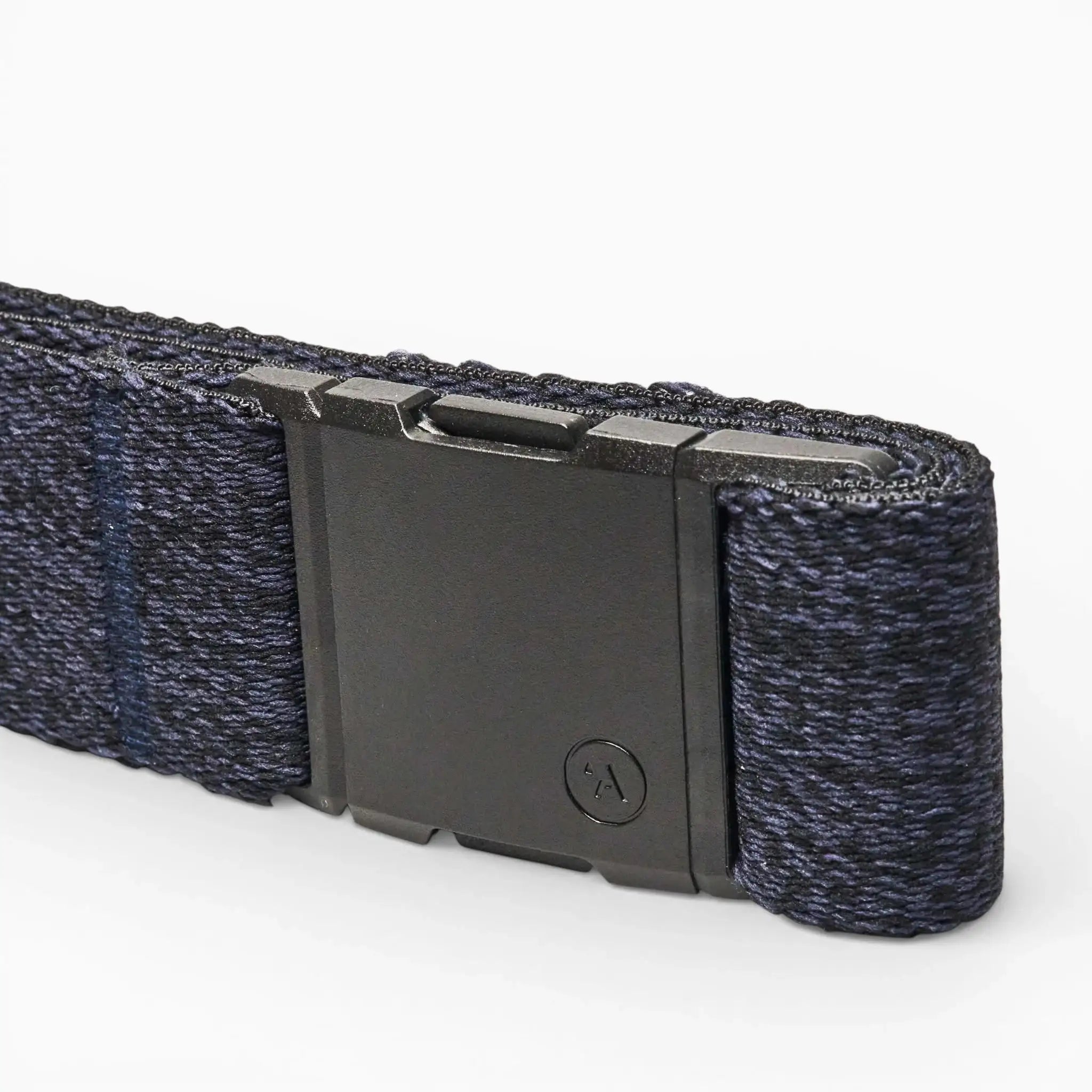 A close-up of the Atlas Low Profile Belt by Arcade Belts in navy blue, showcasing stretch webbing and a matte black rectangular buckle, set against a plain light background.