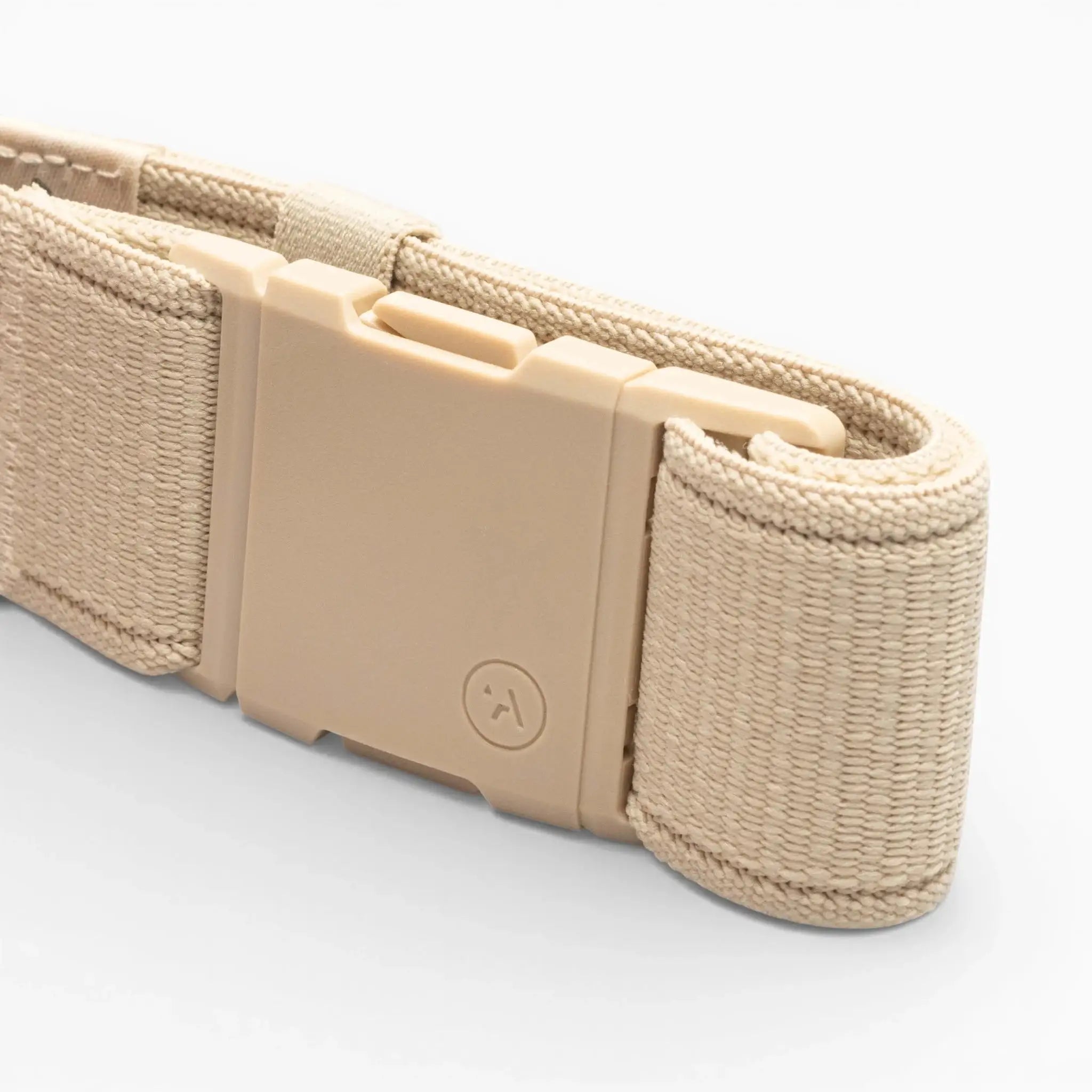 A close-up of a beige woven Atlas belt by Arcade Belts with a rectangular plastic buckle, featuring a small smiley face on the buckle, set against a plain white background.