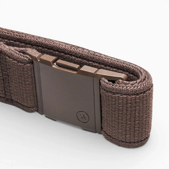 A close-up of the Atlas belt by Arcade Belts, featuring a brown woven elastic stretch design, low-profile style, and a rectangular matte-finish metal buckle, shown against a white background.