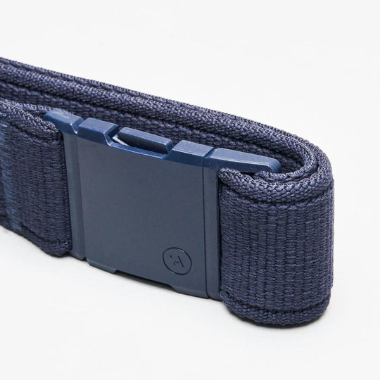 Close-up of the Atlas elastic stretch belt by Arcade Belts, in dark blue, featuring a rectangular plastic buckle, set against a plain white background.
