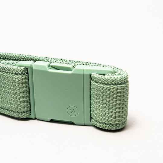 A close-up of the Atlas belt by Arcade Belts shows its mint green stretch webbing strap and matching plastic buckle, set against a plain white background.