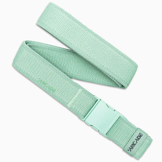 The Atlas by Arcade Belts is a mint green low profile belt crafted from woven stretch webbing, finished with a matching plastic buckle and grey ARCADE logo near the end—perfect for travel belt fans who value comfort and style.