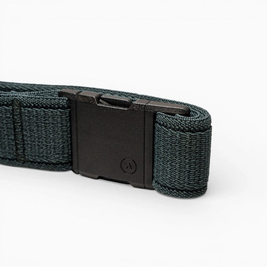 A close-up of an Atlas belt by Arcade Belts features a dark green woven strap and a black plastic buckle, displayed on a light gray background.