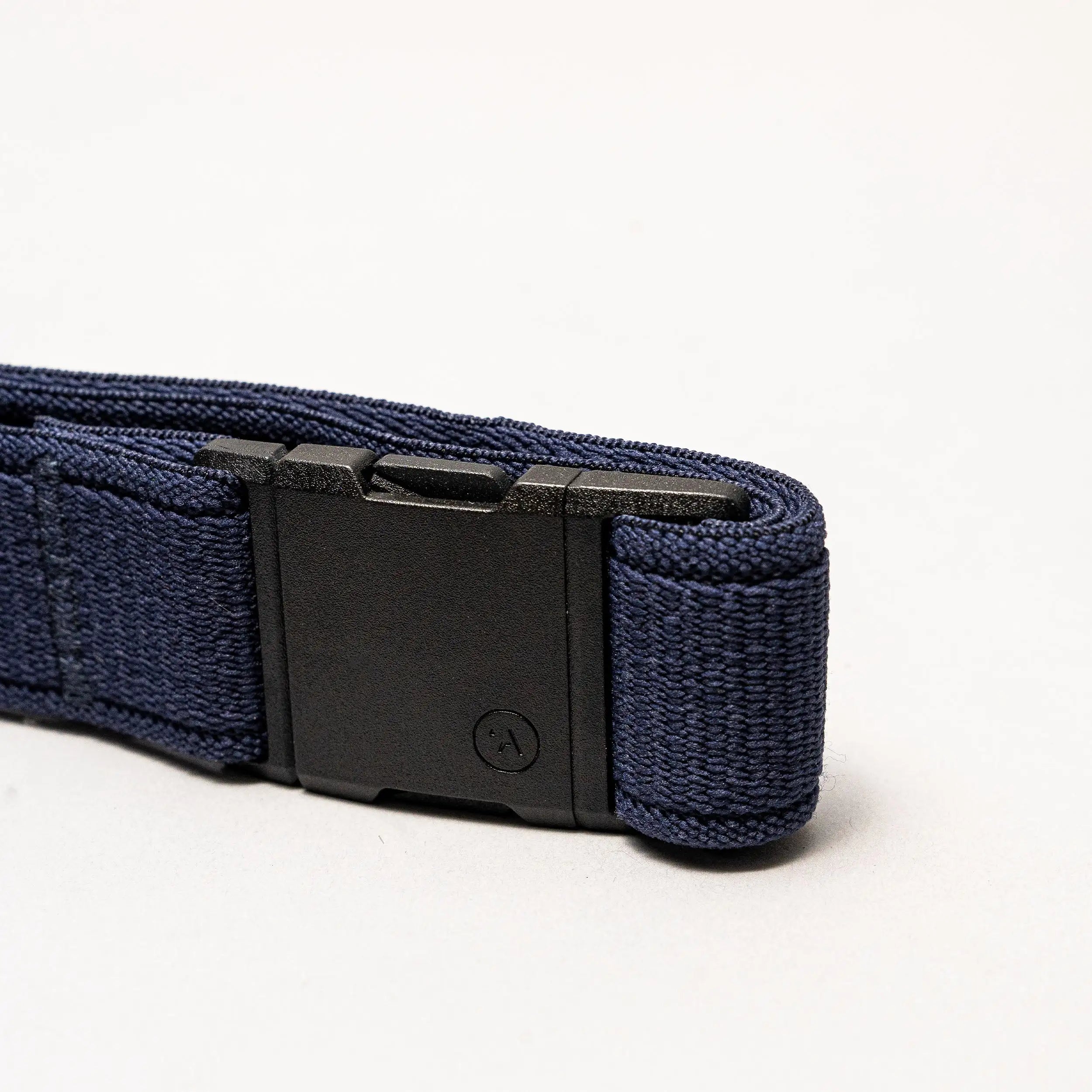 A close-up of the Atlas belt by Arcade Belts, featuring a navy blue elastic strap and a rectangular black plastic buckle, set against a plain light background.