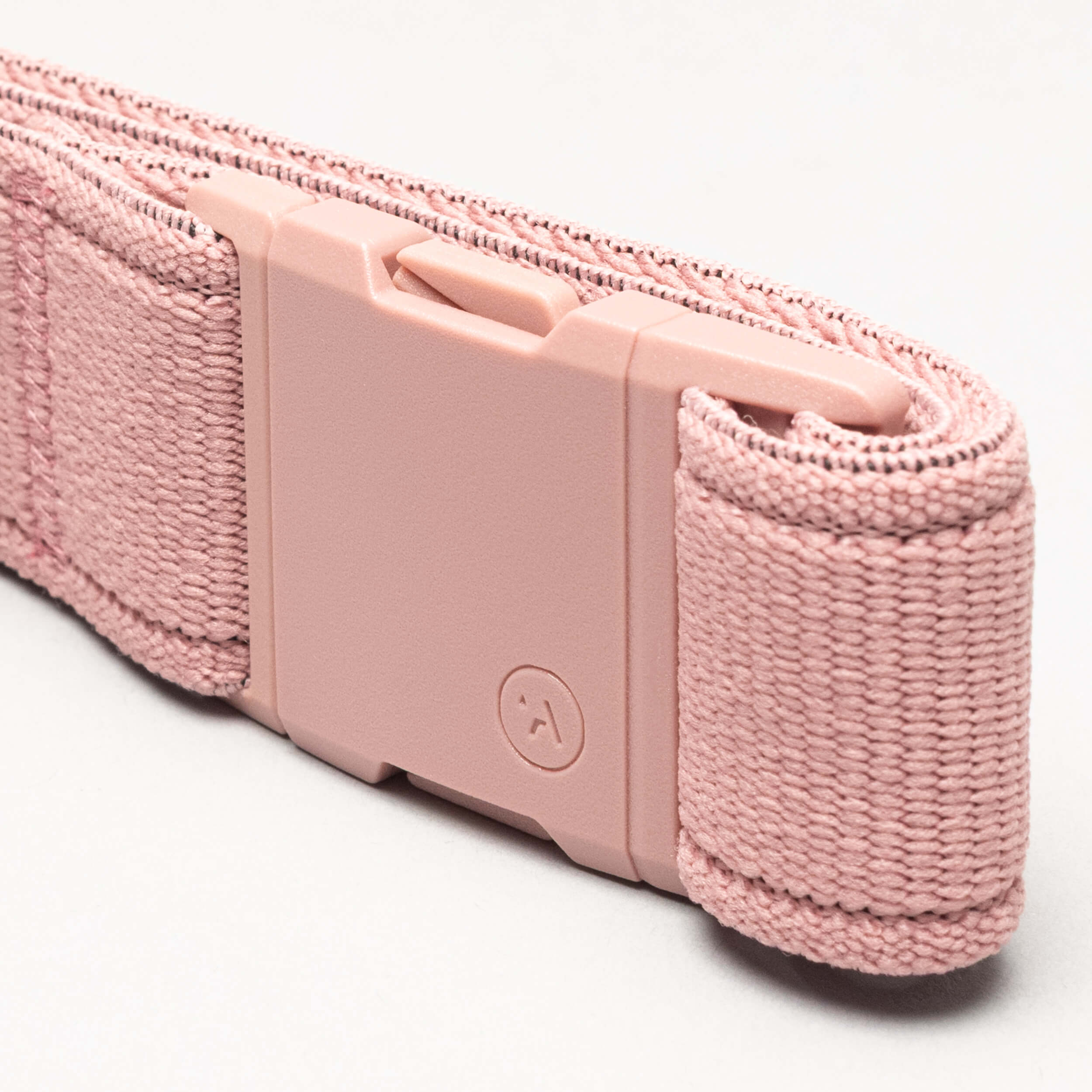 A close-up of the Atlas adventure belt by Arcade Belts, featuring a pink woven strap and matching pink rectangular plastic A2 buckle, neatly rolled on a light background.