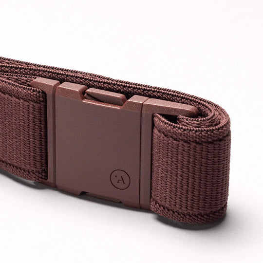 The Atlas belt by Arcade Belts, featuring a brown stretch woven design and a rectangular plastic buckle, is shown in close-up against a plain white background.