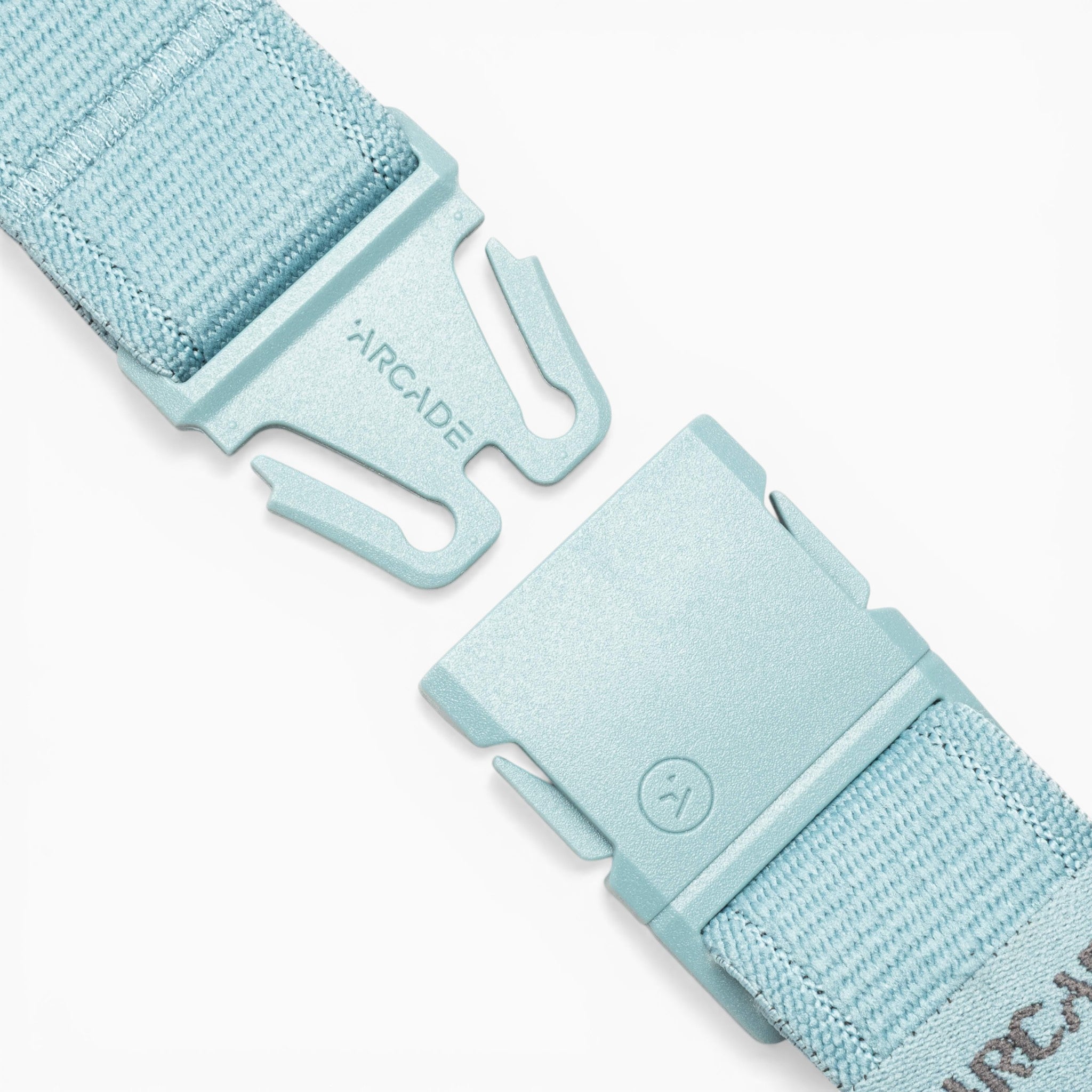 Close-up of the Atlas adventure belt by Arcade Belts in light blue, featuring a partially unfastened plastic A2 buckle engraved with the Arcade logo. Designed for easy adjustment, the woven fabric strap showcases Arcade Belts’ dedication to durable, comfortable performance stretch belts.