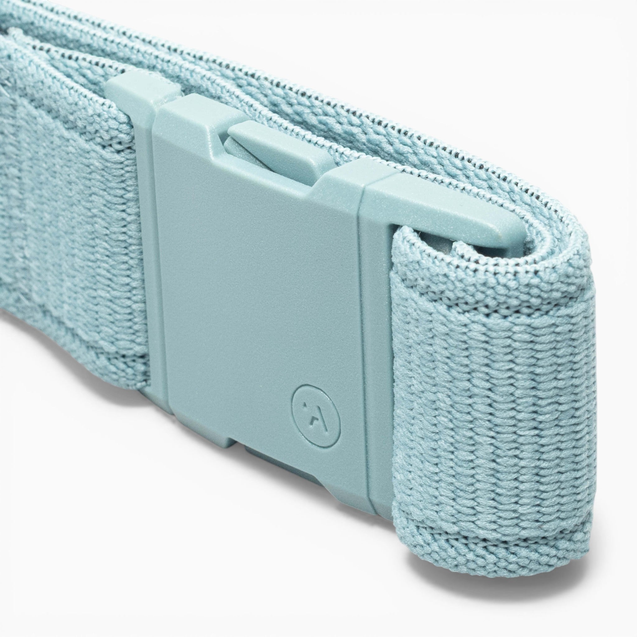 A close-up of the Atlas performance stretch belt by Arcade Belts in light blue woven fabric, featuring a matching plastic A2 buckle embossed with a small circular logo.