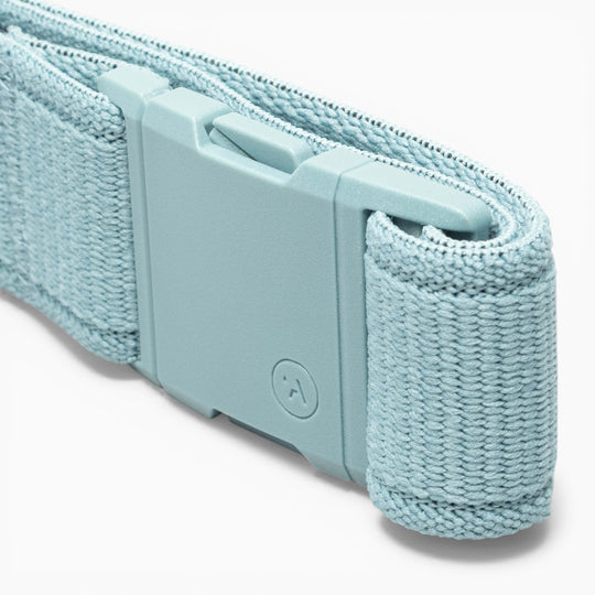 A close-up of the Atlas performance stretch belt by Arcade Belts in light blue woven fabric, featuring a matching plastic A2 buckle embossed with a small circular logo.