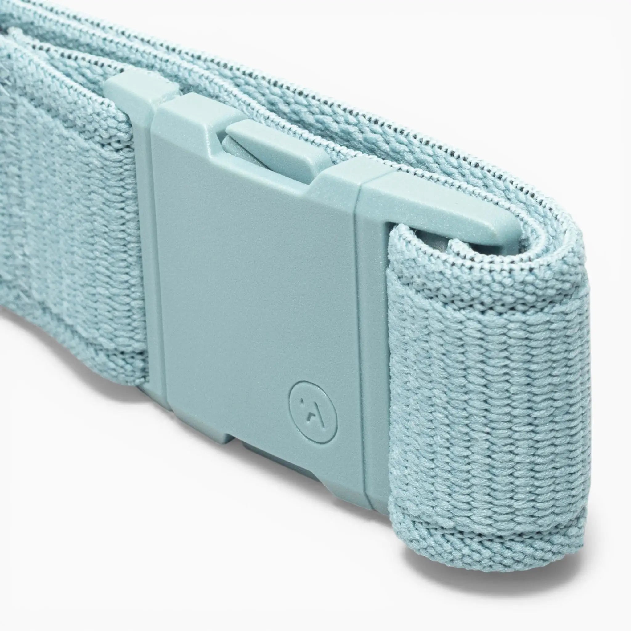 A close-up of the Atlas performance stretch belt by Arcade Belts in light blue woven fabric, featuring a matching plastic A2 buckle embossed with a small circular logo.
