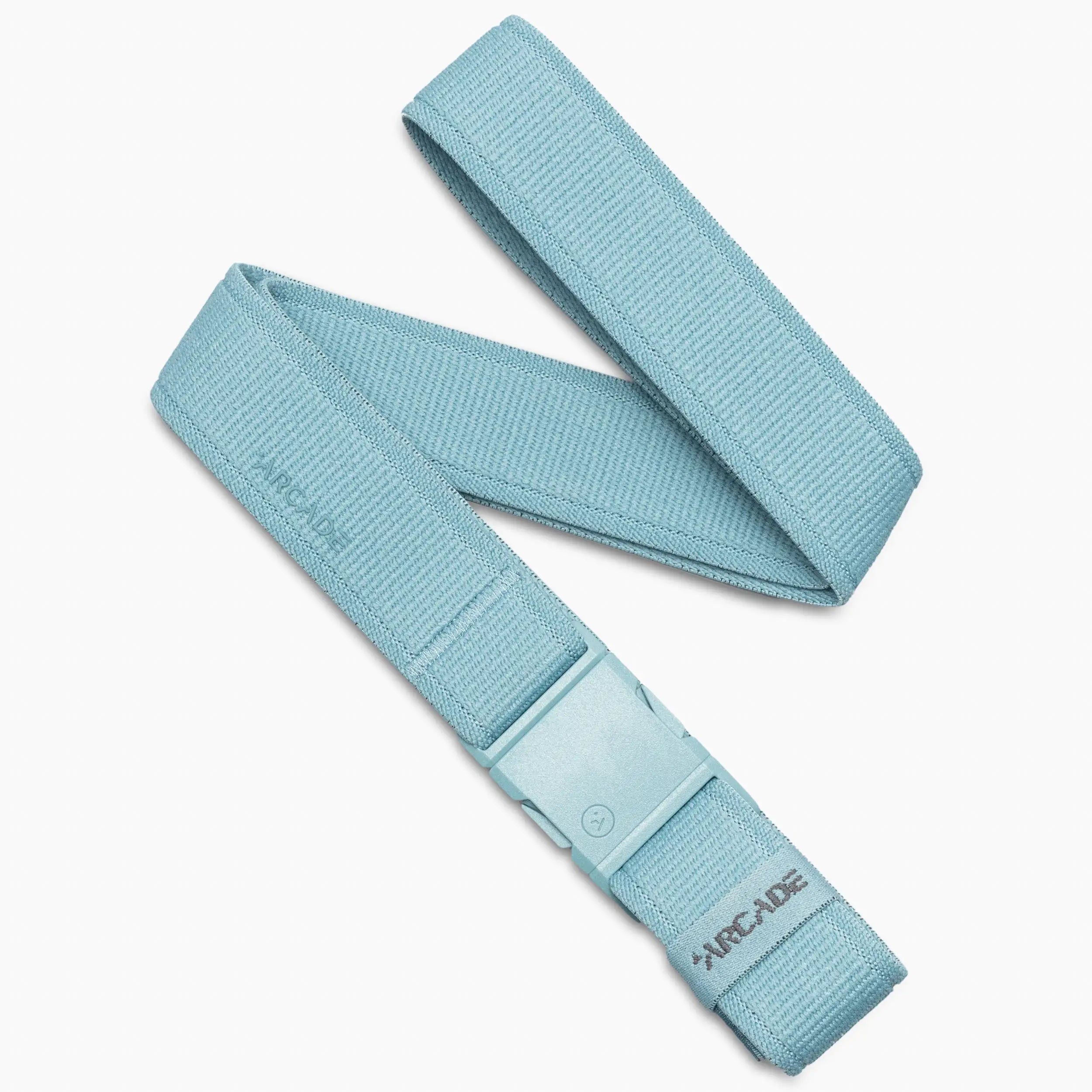 A Cove-colored, woven fabric Atlas adventure belt from Arcade Belts is shown coiled loosely, featuring a matching plastic A2 buckle that displays the Arcade logo in gray. This performance stretch belt combines comfort and durability.