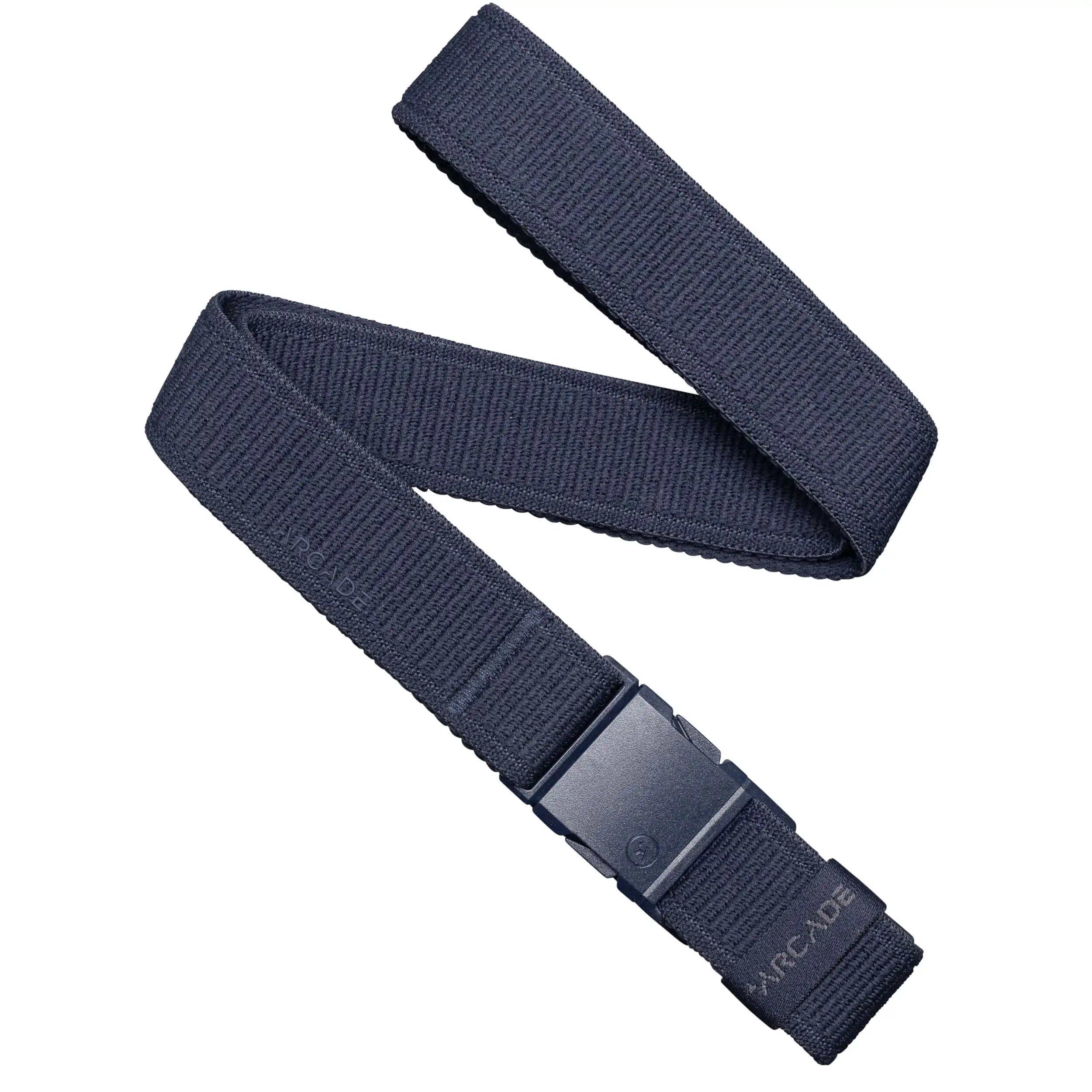 The Atlas Slim Kit by Arcade Belts is a dark blue elastic stretch belt with a black plastic buckle, featuring ARCADE embossed on the end. Its low-profile design offers everyday comfort and travel-ready convenience. Laid out in a zigzag on white.
