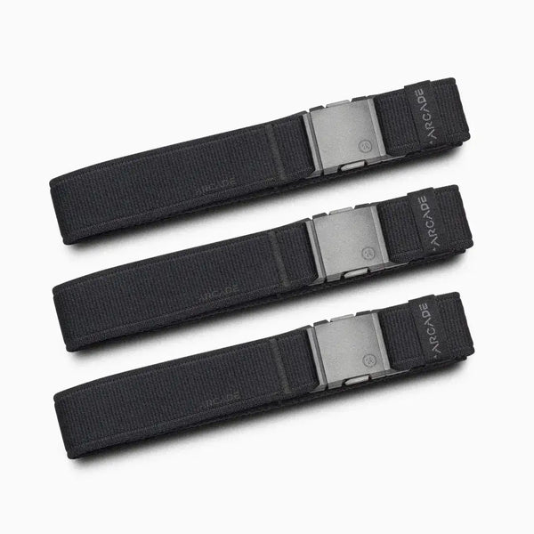 Three identical Atlas Gifting Kit black fabric belts from Arcade Belts, each with a rectangular metal buckle, are arranged parallel to each other on a light gray background. Designed with performance stretch for all-day comfort, the word ARCADE is visible on each belt near the buckle.