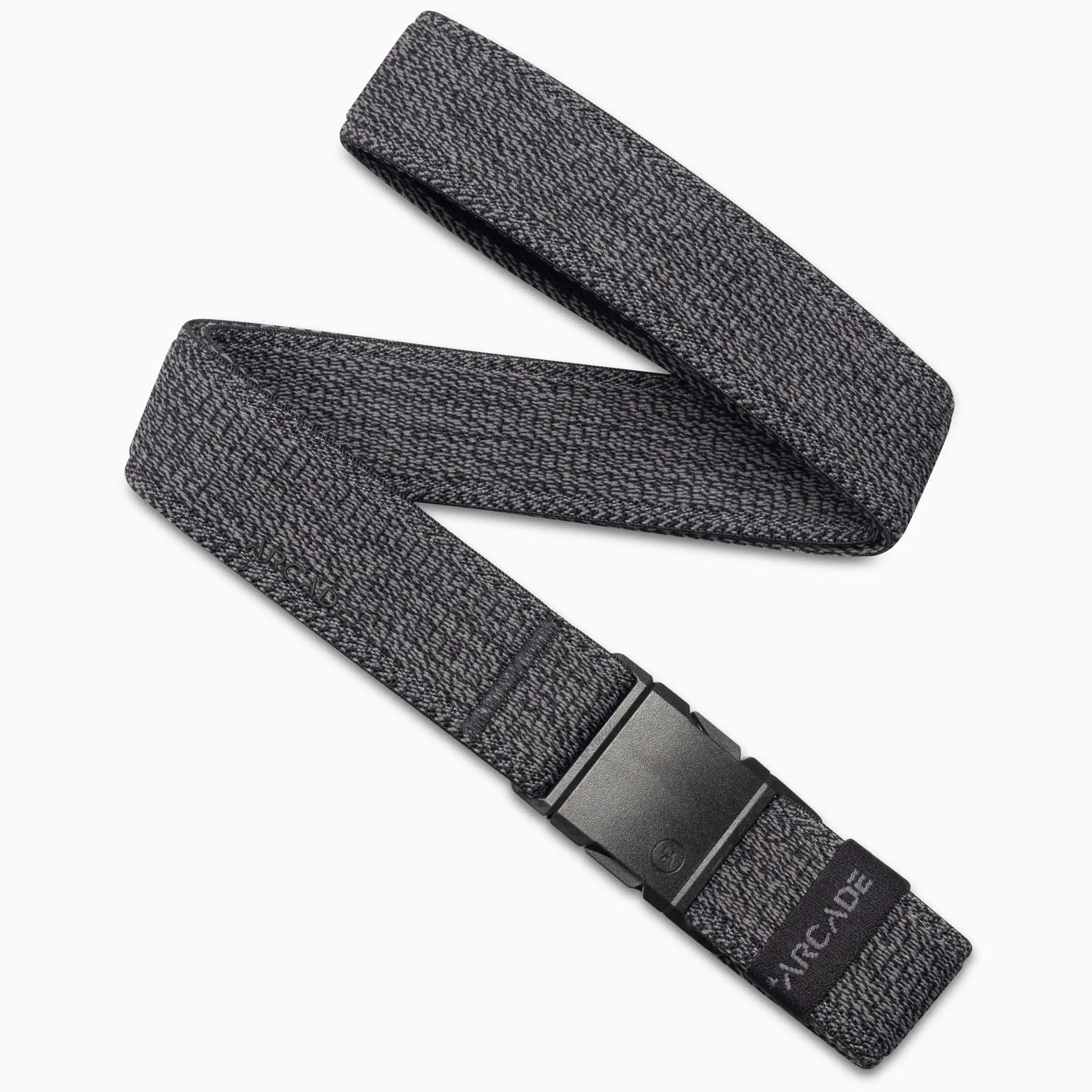 The Atlas by Arcade Belts is a gray woven elastic stretch belt with a subtle pattern and a black plastic buckle. Partially coiled on a white background, the ARCADE logo appears near the buckle.