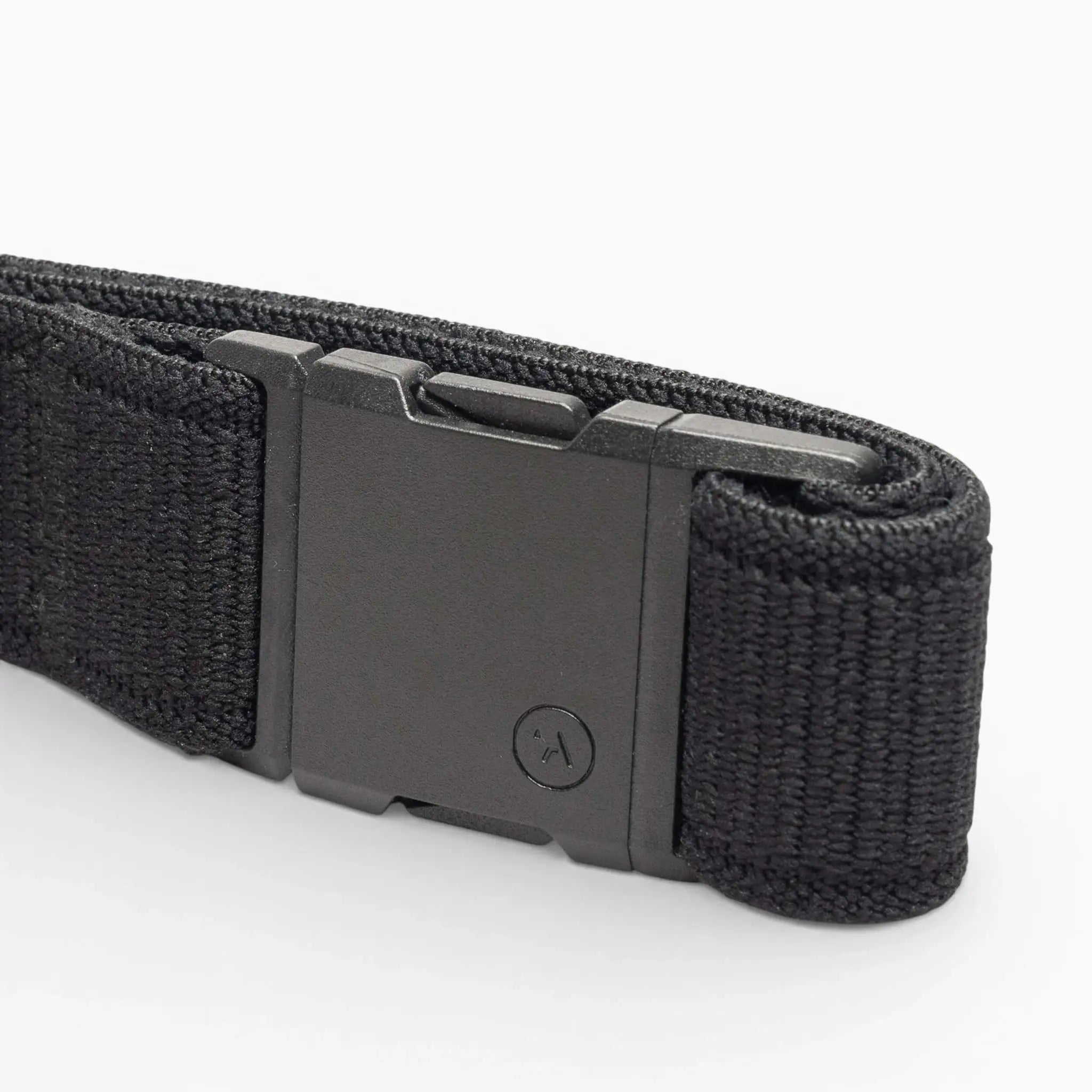 The Atlas by Arcade Belts is a black woven low-profile belt with a matte black rectangular buckle, neatly coiled on a white background—ideal for travel and daily wear.