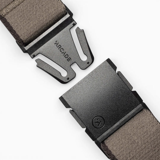 Close-up of the Arcade Belts Blackwood belt, featuring a gray fabric strap and a black metal A2 buckle engraved with "ARCADE," shown open on a light background.